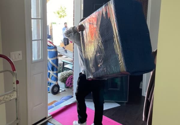 moving a large box into a home during a professional moving service.